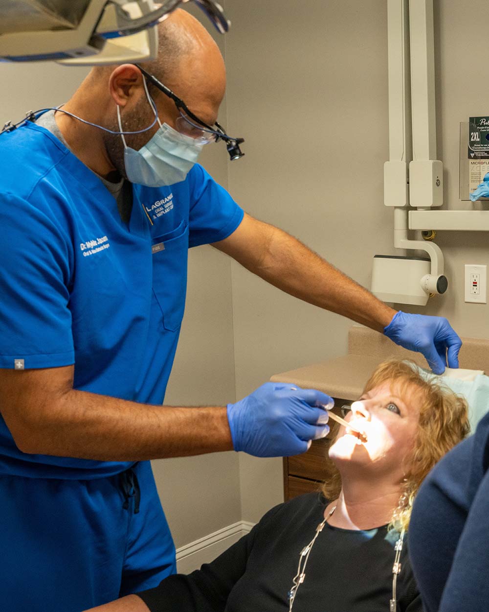 Dr. Mykle Jacobs examines a patient's mouth at LaGrange Oral Surgery and Implant Center.