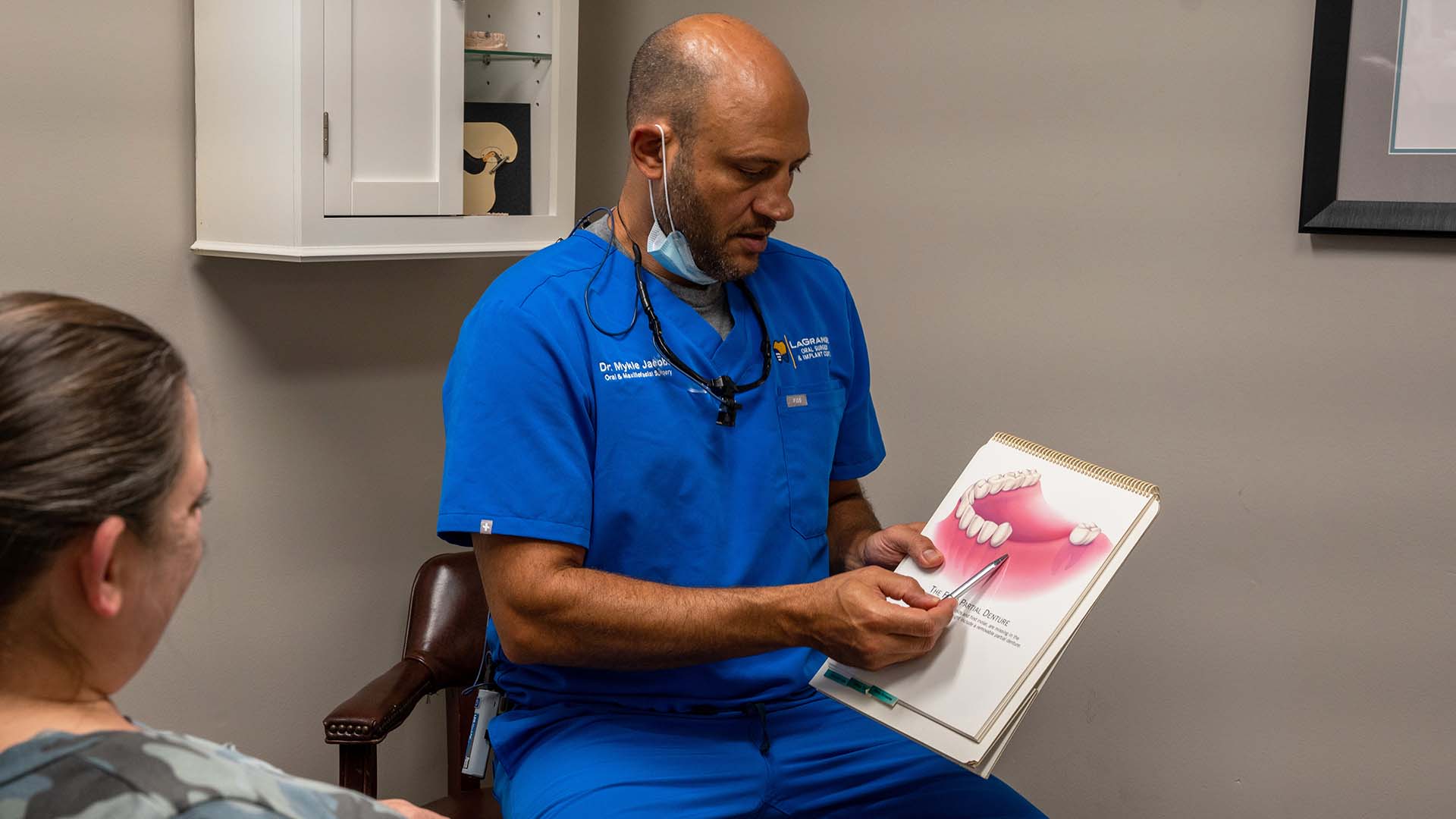 Dr. Mykle Jacobs explains an oral surgery procedure to a patient.