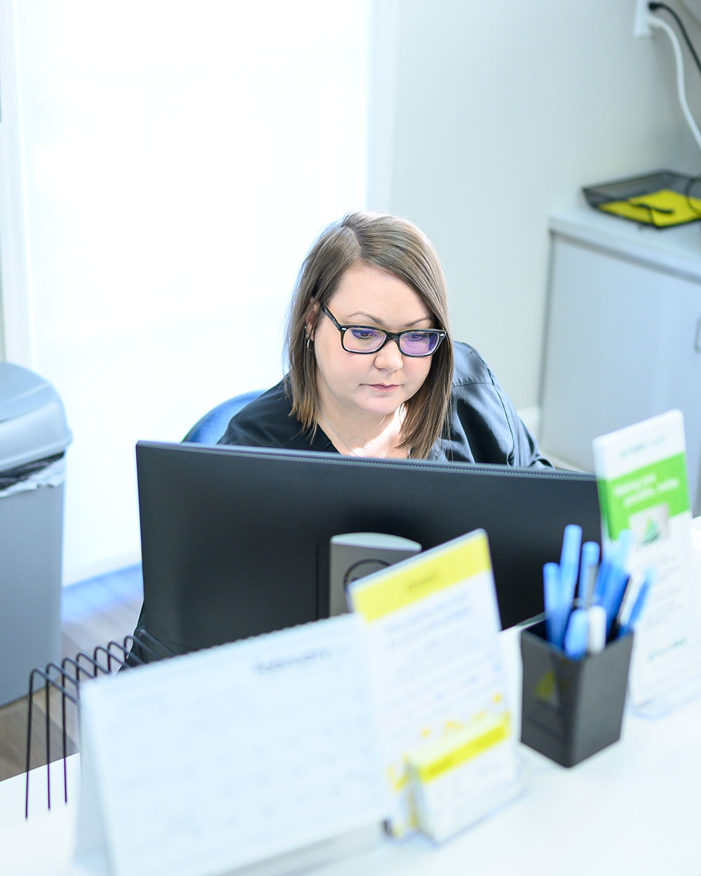 A LaGrange Oral Surgery and Implant Center staff member works on patient paperwork.
