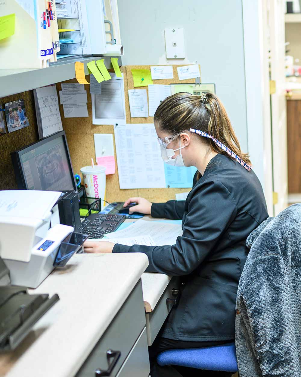 A LaGrange Oral Surgery and Implant Center staff member works on patient paperwork.