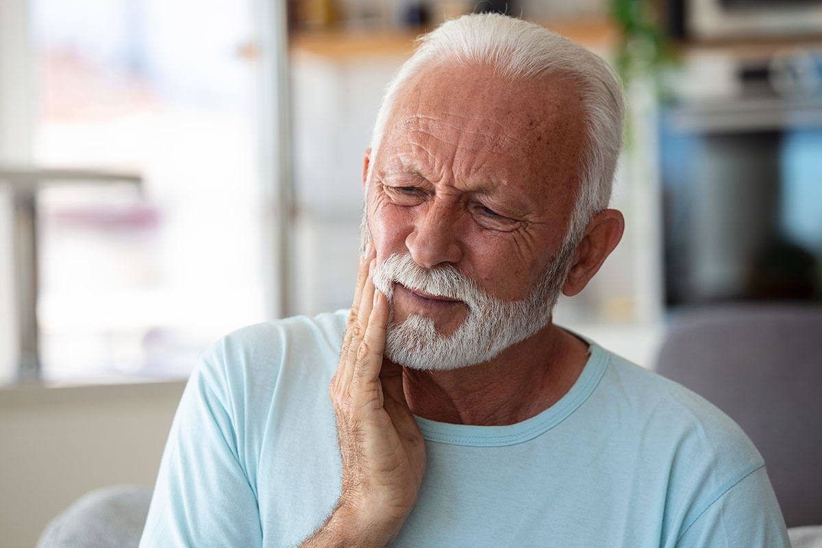 A man experiences tooth pain from his dental implant.