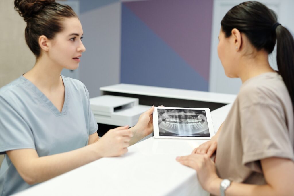 A woman talks to a dentist about oral x-rays.